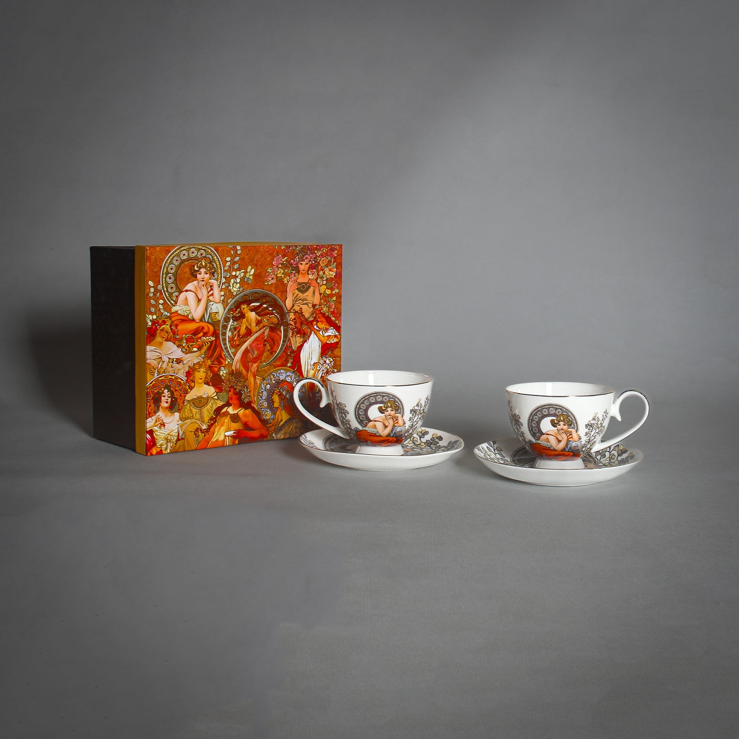 Mucha White Tea Cups and Saucers with a decorative box on the grey background