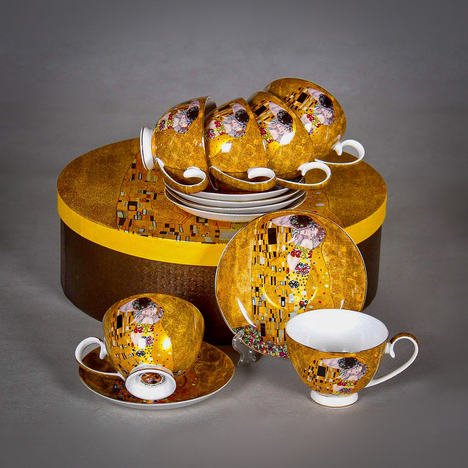 front and side view of Gustav Klimt The Kiss Cup 12 piece set with gift box on a grey background