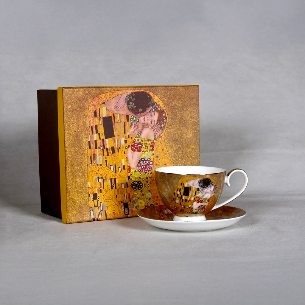front and side view of Gustav Klimt The Kiss Cup and a matching saucer on a grey background