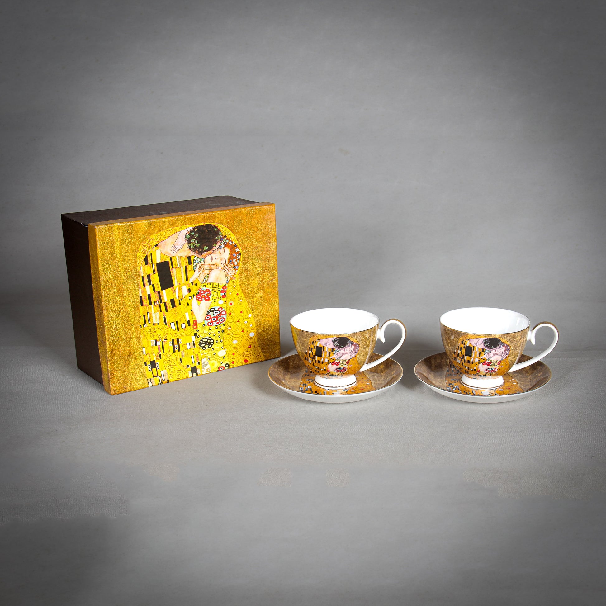 front and side view of Gustav Klimt The Kiss Cups and saucers with gift box a matching tray on a grey background