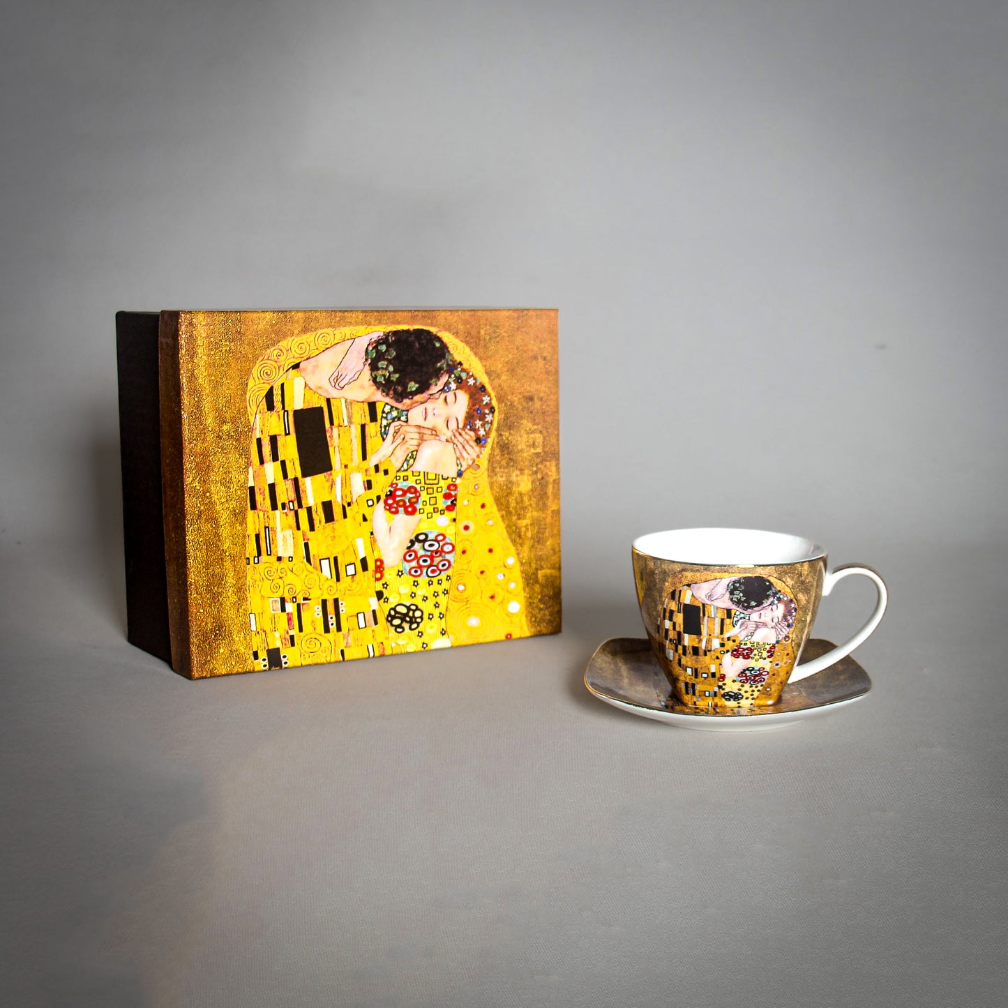 front and side view of Gustav Klimt The Kiss Cup and a matching saucer on a grey background