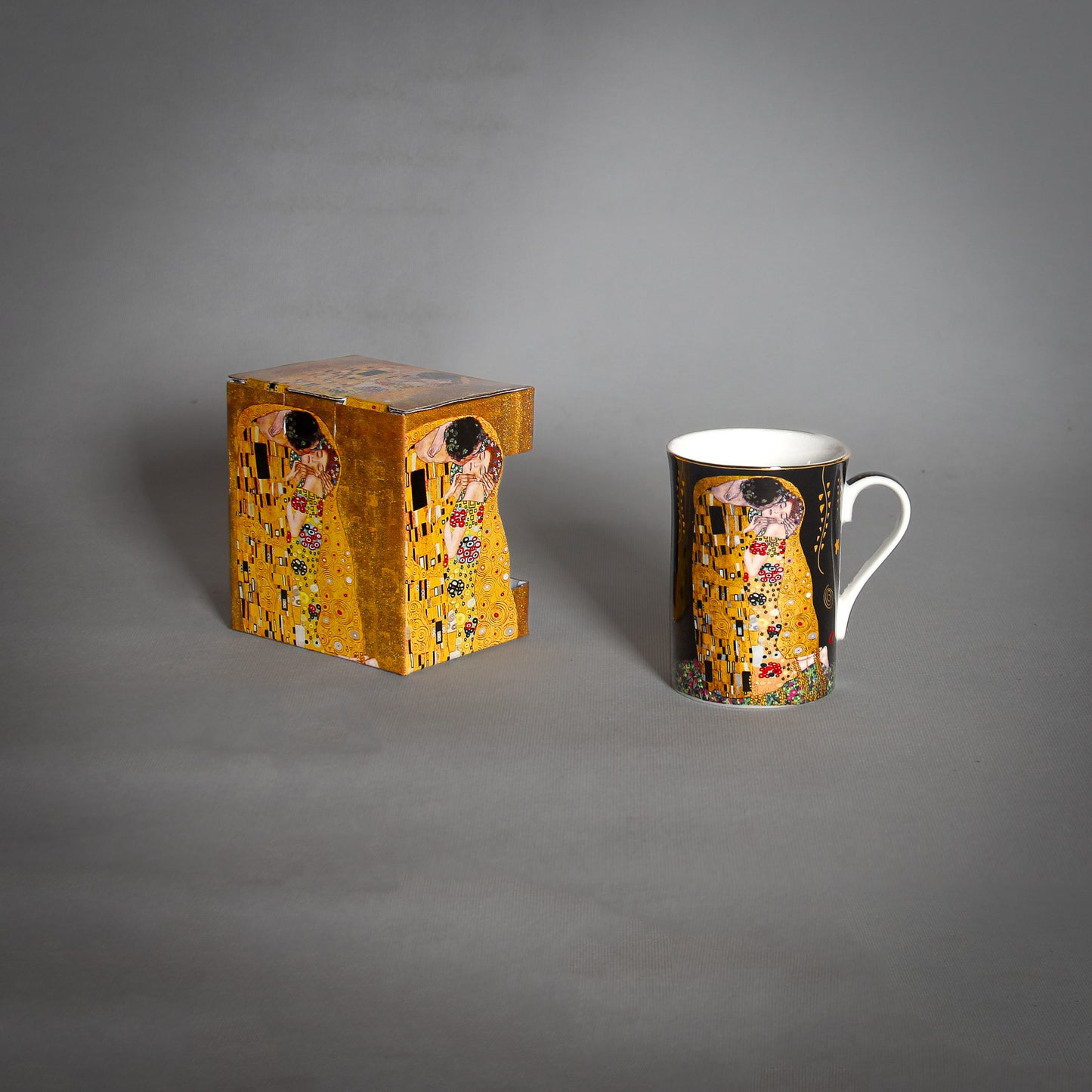 front and side view of Gustav Klimt The Kiss Mug and a matching saucer on a grey background