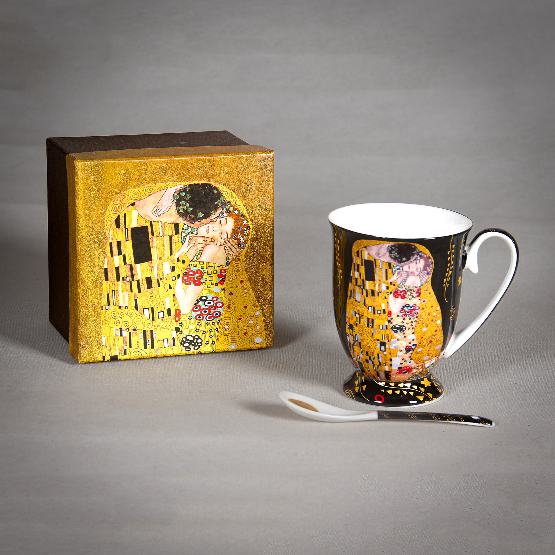 front and side view of Gustav Klimt The Kiss Mug and a matching saucer on a grey background