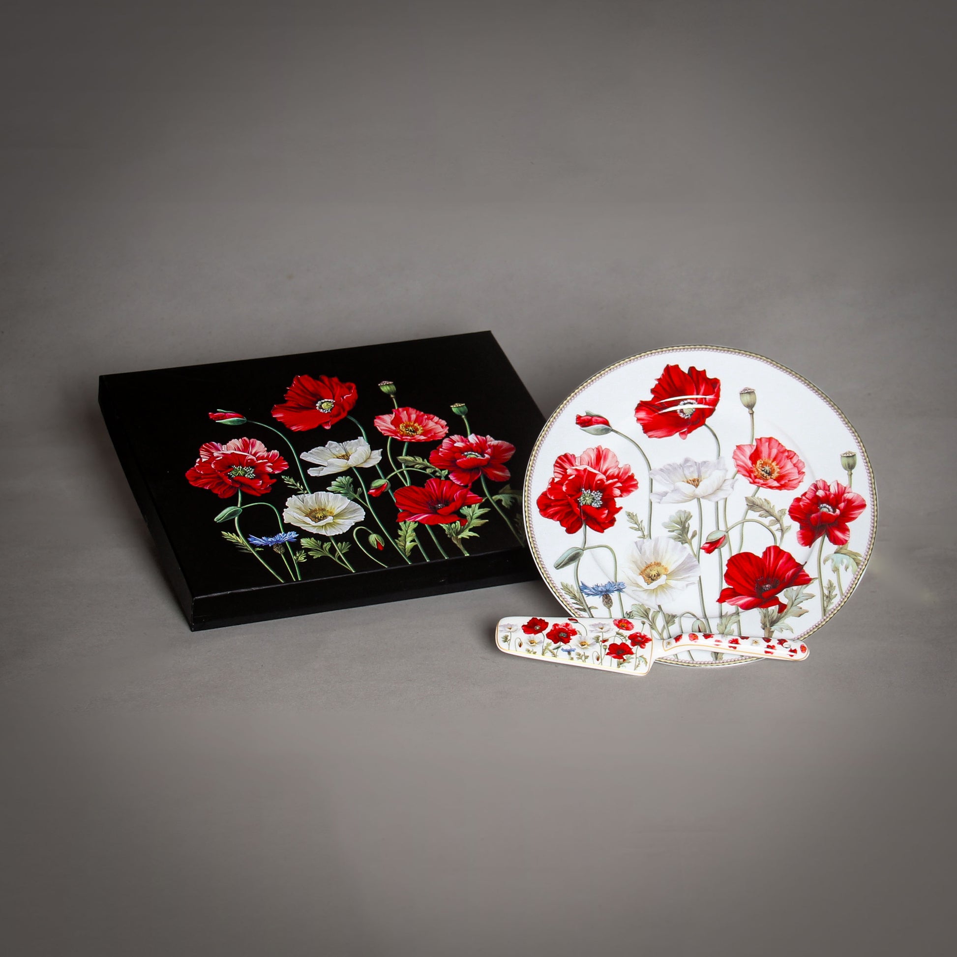 "The Poppy" White Plate and a black box with poppies on the grey background 